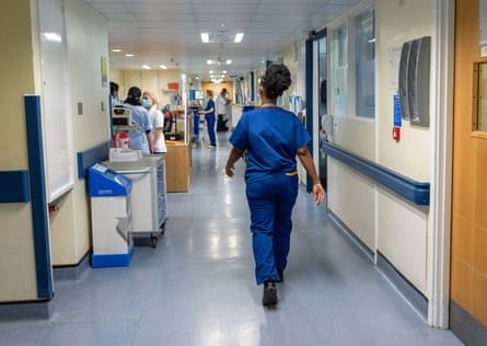 Сотрудники NHS идут по больничному коридору